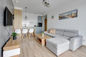 a living room with a couch and a table at Wave Apartments - Zajezdnia Wrzeszcz 2 in Gdańsk