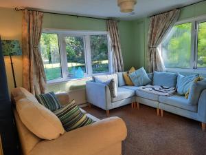 uma sala de estar com dois sofás e duas janelas em Cerdyn Villa em Llanwrtyd Wells