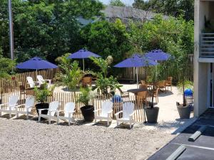 a patio with chairs and tables and umbrellas at Crosswinds Rehoboth Beach in Rehoboth Beach