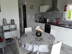 a kitchen with a table with a vase of flowers on it at La Rivière in Pujols Gironde