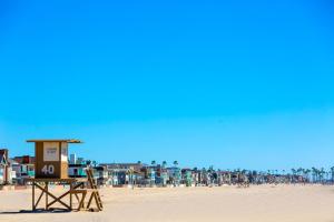 un bagnino sulla spiaggia con persone sullo sfondo di Modern Newport Beach Condos a Newport Beach