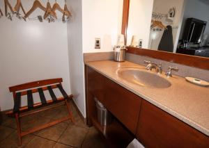 a bathroom with a sink and a mirror and a chair at Crosswinds Motel in Rehoboth Beach