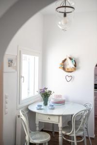 a white dining room with a white table and chairs at Flora's House & Cave Winery in Pirgos