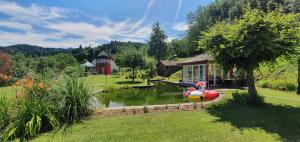 ein Haus mit einem Boot in einem Teich im Hof in der Unterkunft Paradies 2 Castellberg-Jakobsweg in Kastelhof