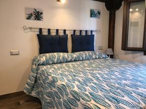 a bedroom with a bed with a blue and white comforter at villetta san teodoro 7 posti IUN Q7135 in San Teodoro