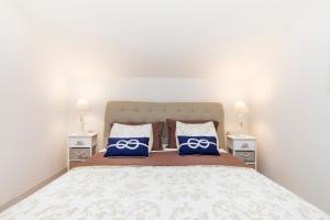 a bedroom with a large bed with two night stands at Apartments Priko 63 in Mali Lošinj
