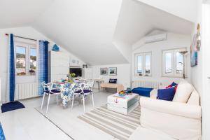 a white living room with a white couch and a table at Apartments Priko 63 in Mali Lošinj