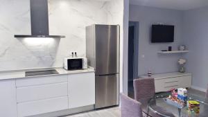 a kitchen with a stainless steel refrigerator and a table at Apartamento los Acantilados Nº 2 Cobreces in Cóbreces