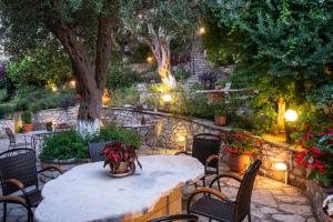 a table and chairs in a garden at night at Hotel Oriana - Adults Only in Syvota