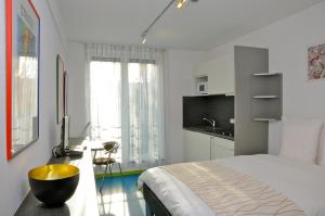 a bedroom with a bed and a desk with a sink at Domus Hotel in Luxembourg