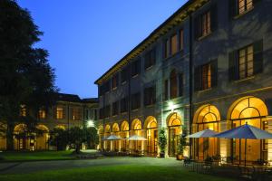 a building with tables and umbrellas in front of it at Centro Paolo VI in Brescia