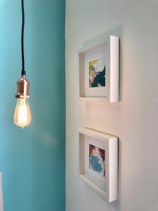 a couple of framed pictures on a wall with a light at La Siesta in La Maddalena