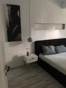 a bedroom with a bed and a side table at Luxury Apartament Craiova Central in Craiova