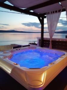 a hot tub with a view of the water at Apartments Ivo in Novigrad Dalmatia