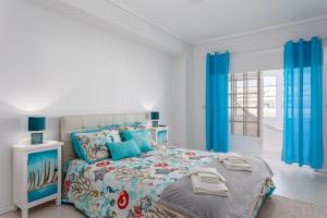 1 dormitorio con 1 cama grande y cortinas azules en Marinha- AL en Praia da Vagueira