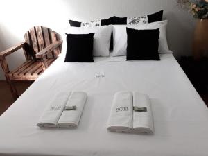 a large white bed with two pillows and a chair at Hotel Rosa Viva in Barretos