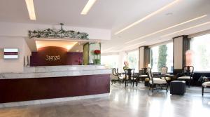 een salon met een wachtkamer met tafels en stoelen bij Stanza Hotel in Mexico-Stad