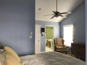 - une chambre avec des murs bleus et un ventilateur de plafond dans l'établissement Cresthaven By the Sea, à South Maitland