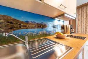 a kitchen with a large painting on the wall at Haus Martina in Tux