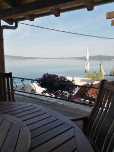 een balkon met een tafel en uitzicht op de oceaan bij Apartments Ivo in Novigrad Dalmatia