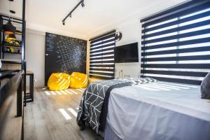 a bedroom with a bed and two yellow bags at Studio Temático Bem Espaçoso - ALL1503 in Curitiba +33 photos