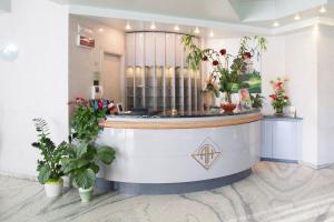 a lobby with a counter with plants and flowers at Hotel Ambasciatori in Pineto