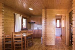 a kitchen with a table and chairs in a cabin at Camping Globo Barcelona in Canet de Mar