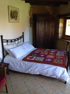 1 dormitorio con 1 cama con edredón en Chambre d'hôtes Lasserre, en Saint-Amand-de-Coly