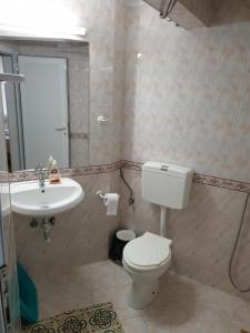 a bathroom with a toilet and a sink at Guest House Juja in Nesebar