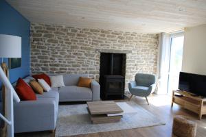sala de estar con sofá y pared de piedra en Ker Karreg (La Maison du Rocher), en Penmarch