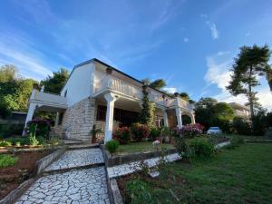 ein weißes Haus mit einer Veranda und einem Hof in der Unterkunft Villa Matohanca in Rovinj