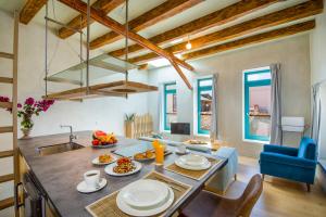 een keuken en een woonkamer met een tafel en een wastafel bij Olvia in Chania