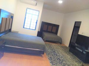 a bedroom with a bed and a flat screen tv at 10 Large suite for 4 people in Torreón