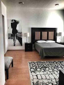 Un dormitorio con una cama y una foto de una mujer en 10 Large suite for 4 people, en Torreón