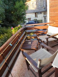 una fila de mesas y sillas de madera en un patio en Guest House Juja en Nesebar