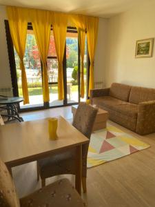 a living room with a table and a couch at Apartment Aquareumal Fojnica in Fojnica