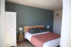 ein Schlafzimmer mit einem Bett und einer grünen Wand in der Unterkunft Ker Karreg (La Maison du Rocher) in Penmarcʼh