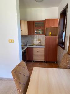 una cucina con armadi in legno, tavolo e sedie di Apartment Aquareumal Fojnica a Fojnica