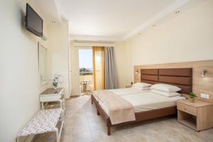 a bedroom with a bed and a desk and a television at Billy's Studios in Faliraki