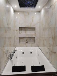 ein weißes Badezimmer mit einer Badewanne und einem Waschbecken in der Unterkunft Airport Apartments in Belgrad