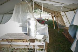 een tent met een blik op een tafel in het gras bij Safaritent Heidschnuckenhof das Camp in Niedermeiser