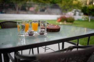 einen Tisch mit vier Gläsern Orangensaft und einem Kuchen in der Unterkunft Aurora Premium Hospitality in Parga