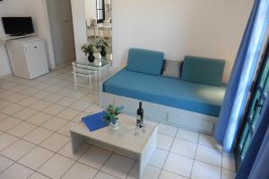 a living room with a blue couch and a table at Julies Apartments in Kokkini Khanion