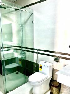 a bathroom with a toilet and a glass shower at Hotel Hạnh Phúc in Ha Long