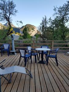 - une table de pique-nique et des chaises sur une terrasse en bois dans l'établissement Auberge du Point Sublime, à Rougon