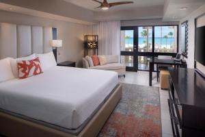 a hotel room with a large bed and a large window at Bucuti & Tara Boutique Beach Resort - Adult Only in Palm-Eagle Beach