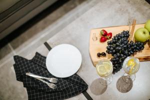 a table with a plate of fruit and glasses of wine at Cosmo Napa Boutique Hotel in Ayia Napa