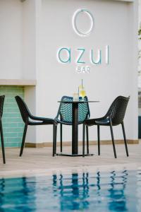 a table and chairs next to a swimming pool at Cosmo Napa Boutique Hotel in Ayia Napa