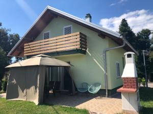 una casa pequeña con porche y faro en Holiday Home-kuća GORICA VERDE, en Fužine