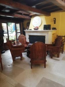 a living room with chairs and a clock above a fireplace at B&B BONE NOVELLE in LʼAquila